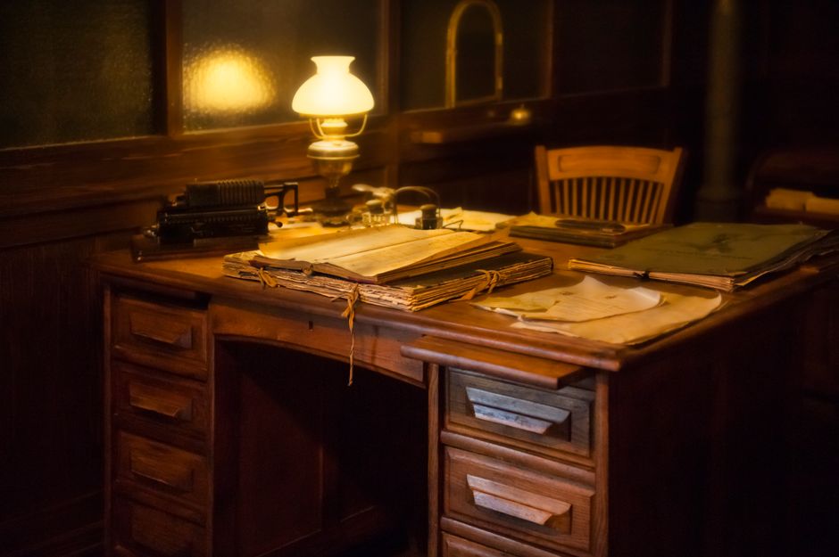 Desk with books and a brass lamp in a quiet study