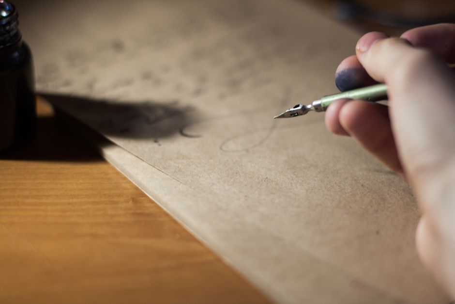 Hand writing with a nib pen on a paper document